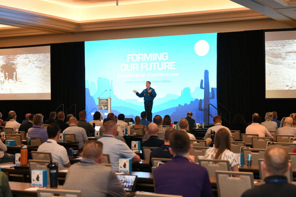 Keynote speaker in packed room of attendees.